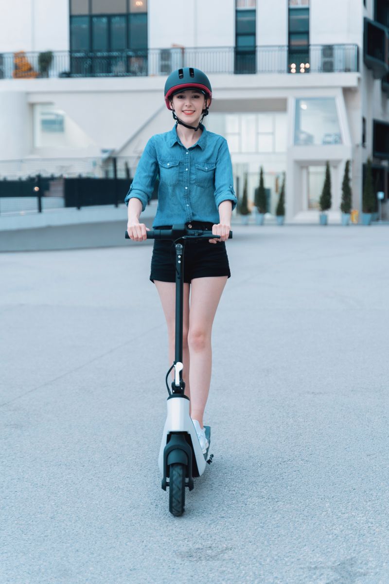 Confident woman riding an electric scooter in modern city environment