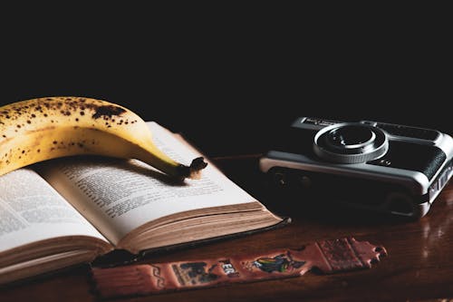 Close-Up Photo of a Yellow Banana on Top of a Book