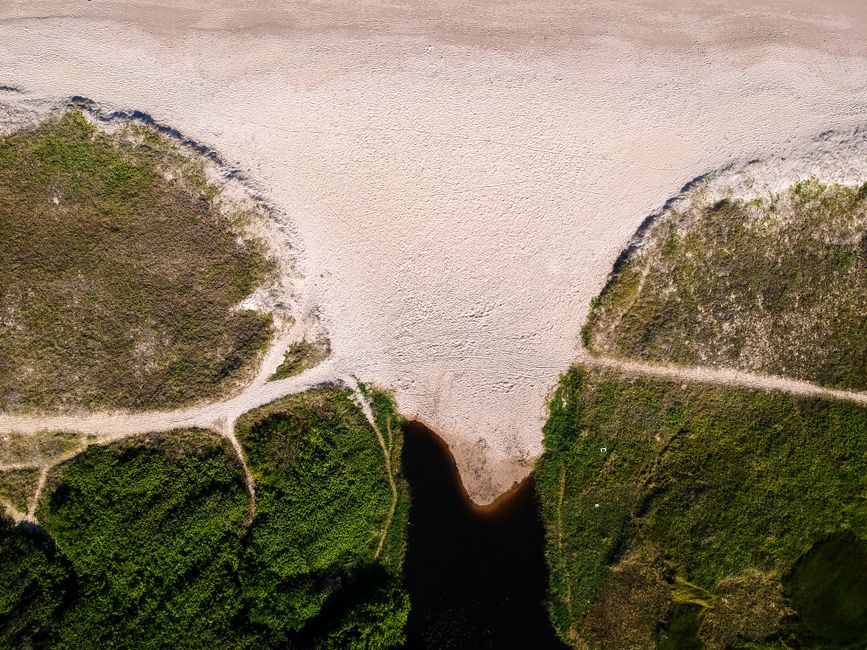 A stunning aerial shot capturing a scenic landscape with sandy shores and lush greenery in Taperoá, Brazil.