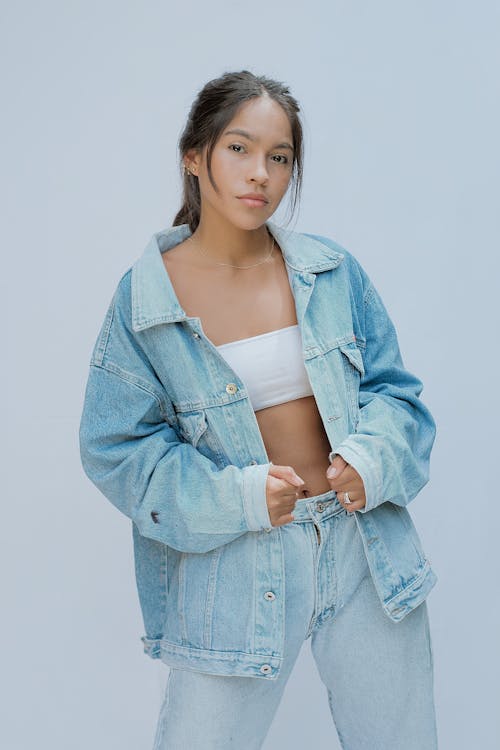 Photograph of a Woman in Denim Clothes Looking at the Camera