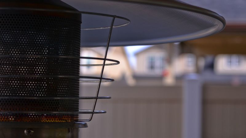 A small infrared space heater glowing bright orange next to an armchair in a cold, drafty room.