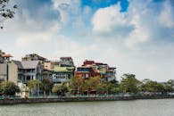 海滨色彩缤纷的房屋在充满活力的天空下排列，展现了城市建筑与自然美景