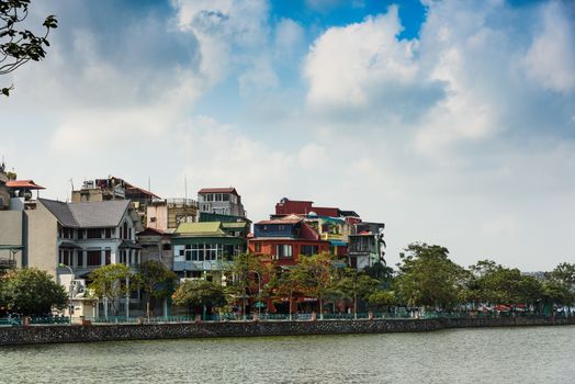 海滨色彩缤纷的房屋在充满活力的天空下排列，展现了城市建筑与自然美景