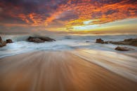 长时间曝光拍摄的日出海滩令人惊叹，海浪动态十足，天空五彩缤纷