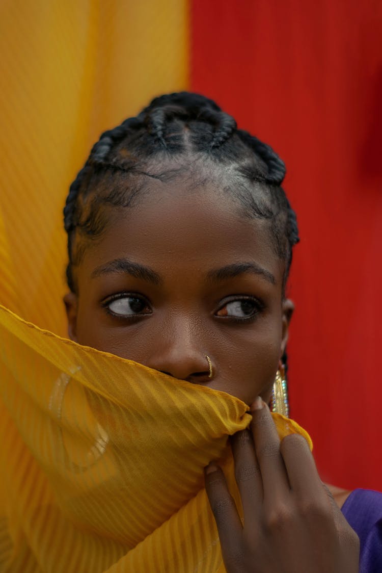 A Woman Covering Her Mouth With A Yellow Cloth