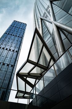 Striking modern skyscrapers with glass facades captured from a low angle, emphasizing their height and design.