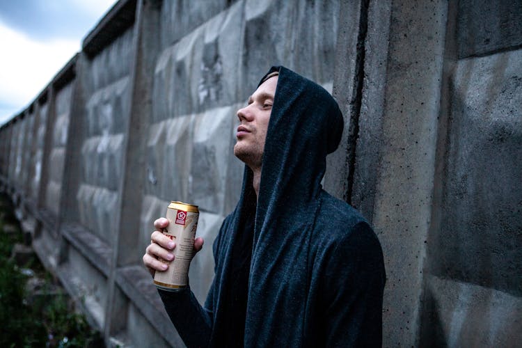 A Man Holding A Can Of Beer 