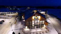 考贝尔啤酒度假村的冬季夜景被灯光点亮，展现出白雪皑皑的景色