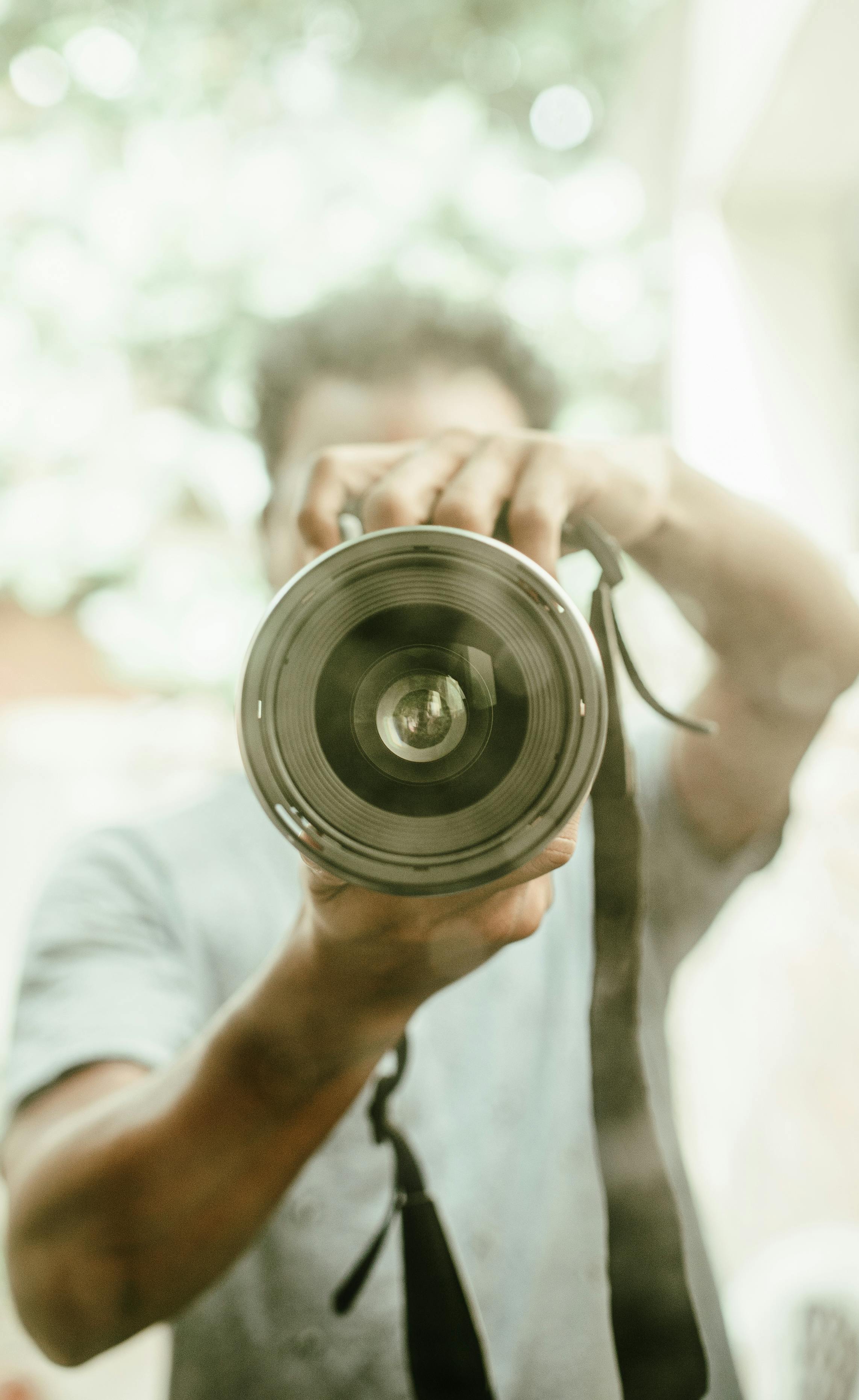 person holding black camera lens