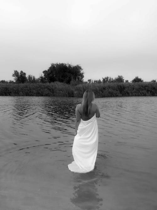Free Back View Shot of Woman in White Dress Standing on Water Stock Photo