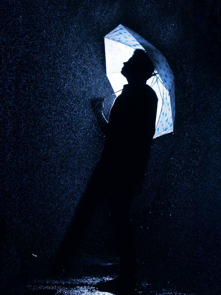 A Man Standing Under The Umbrella During Rainfall