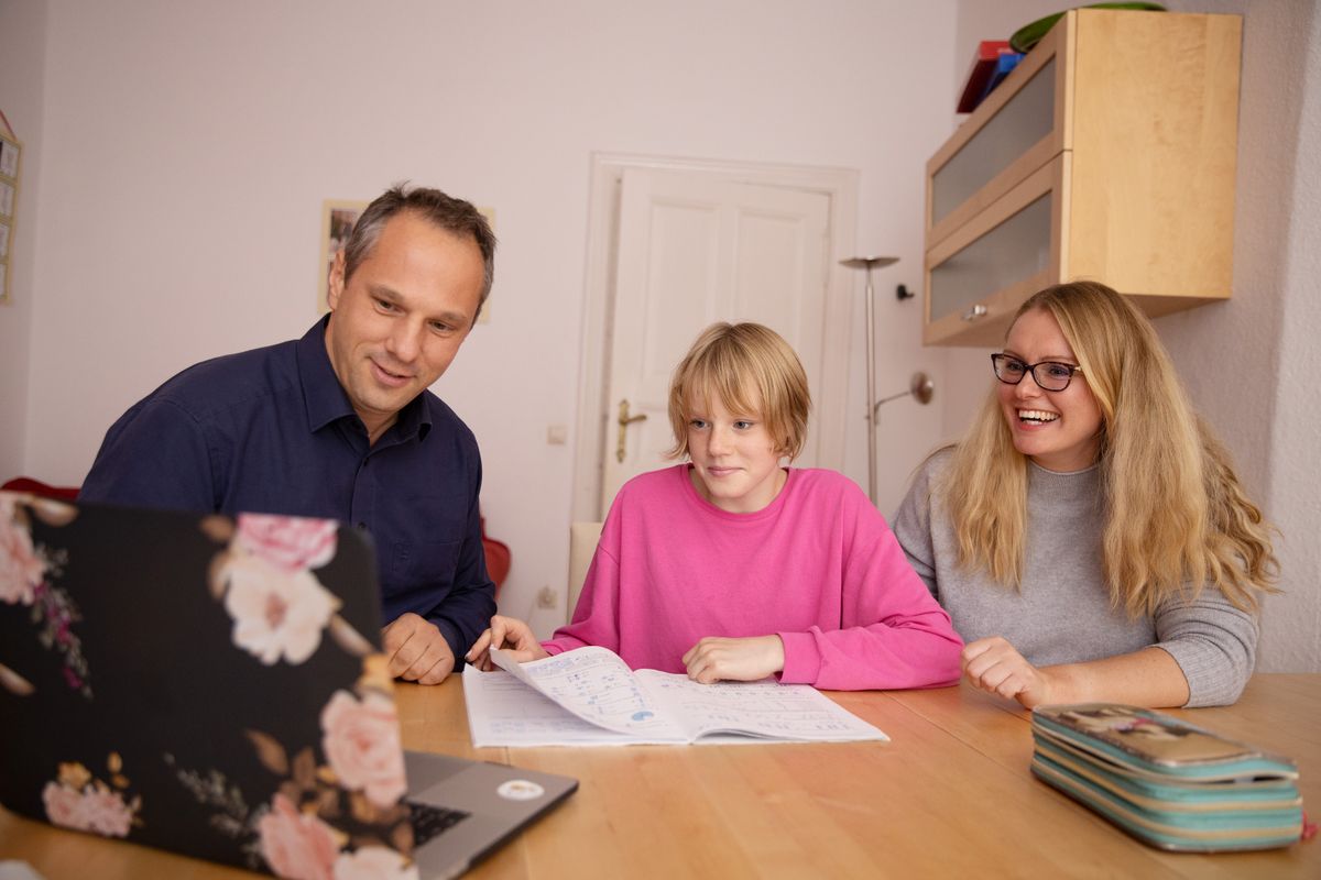 Family looking at a laptop screen together at home