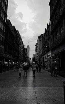 Urban street scene with Torre Latinoamericana in the background, monochrome tones.