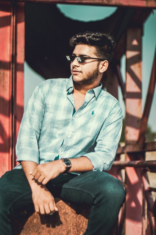 Free Stylish young man in sunglasses posing confidently outdoors in casual attire. Stock Photo