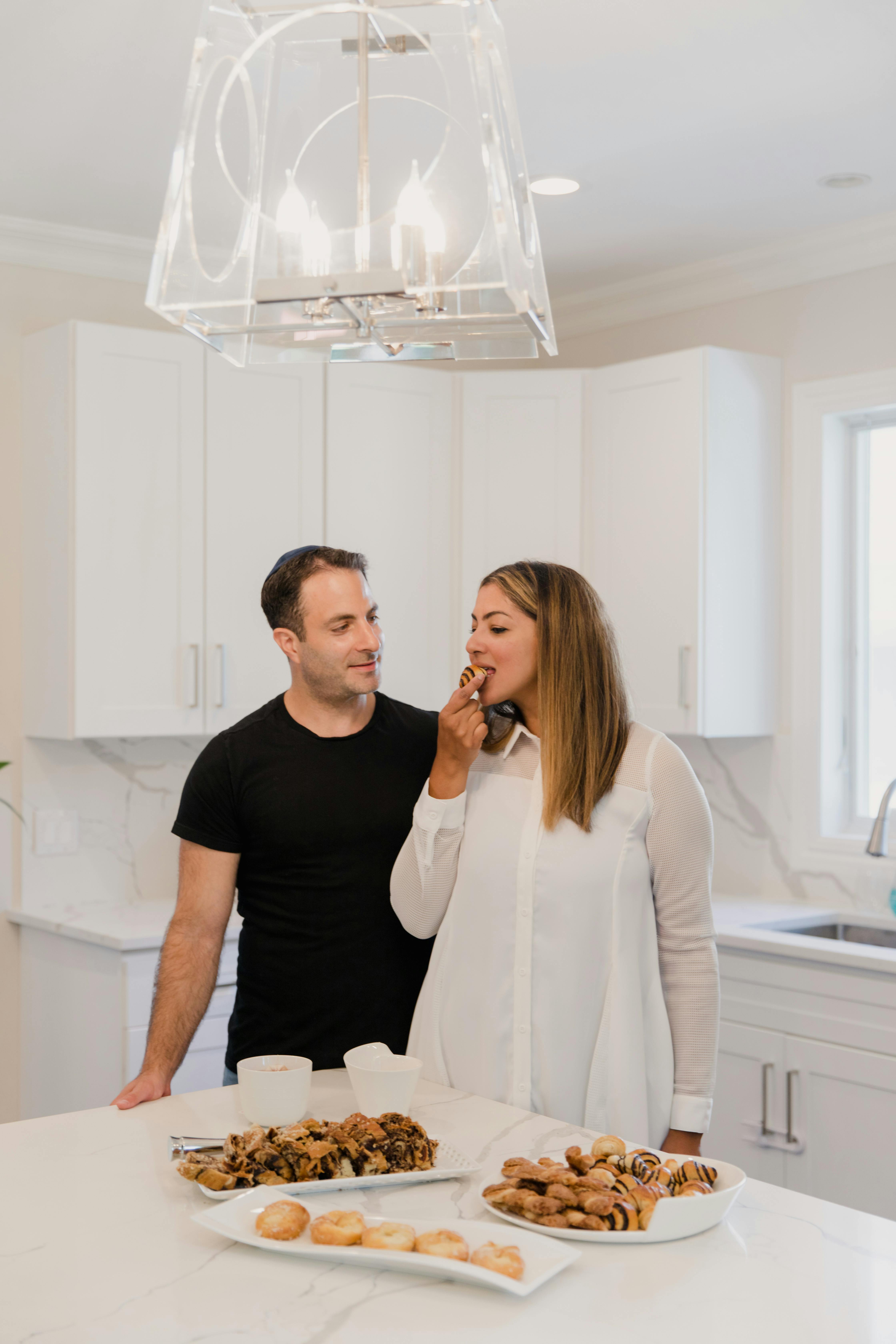 a woman tasting a bread beside a man