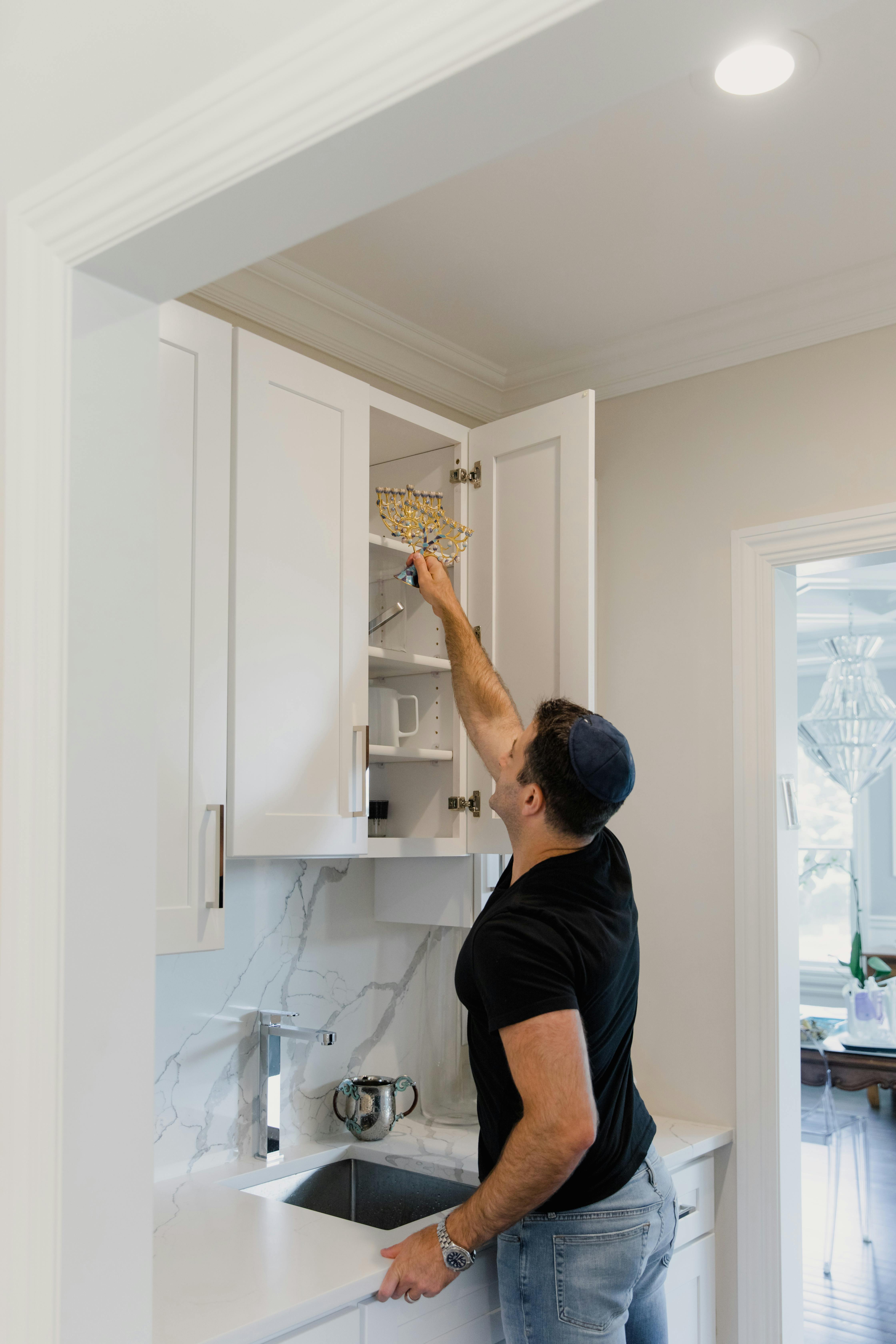 a man in black shirt getting equipment in the cabinet