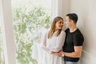A Couple Standing by a Glass Window