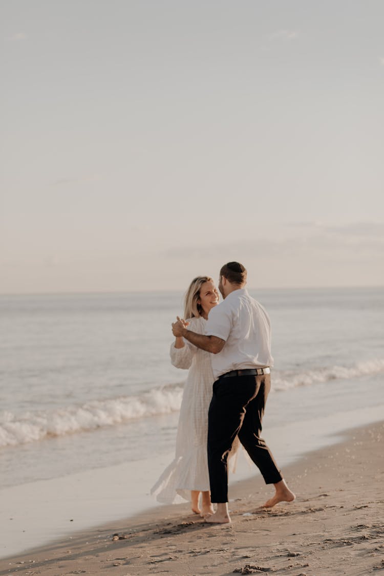 Man And Woman Dancing On The Beach