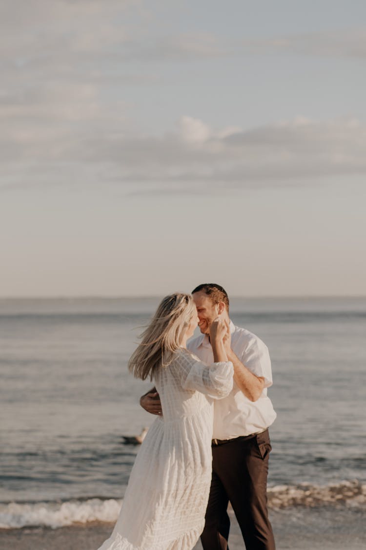 Woman And Man Dancing On The Beach