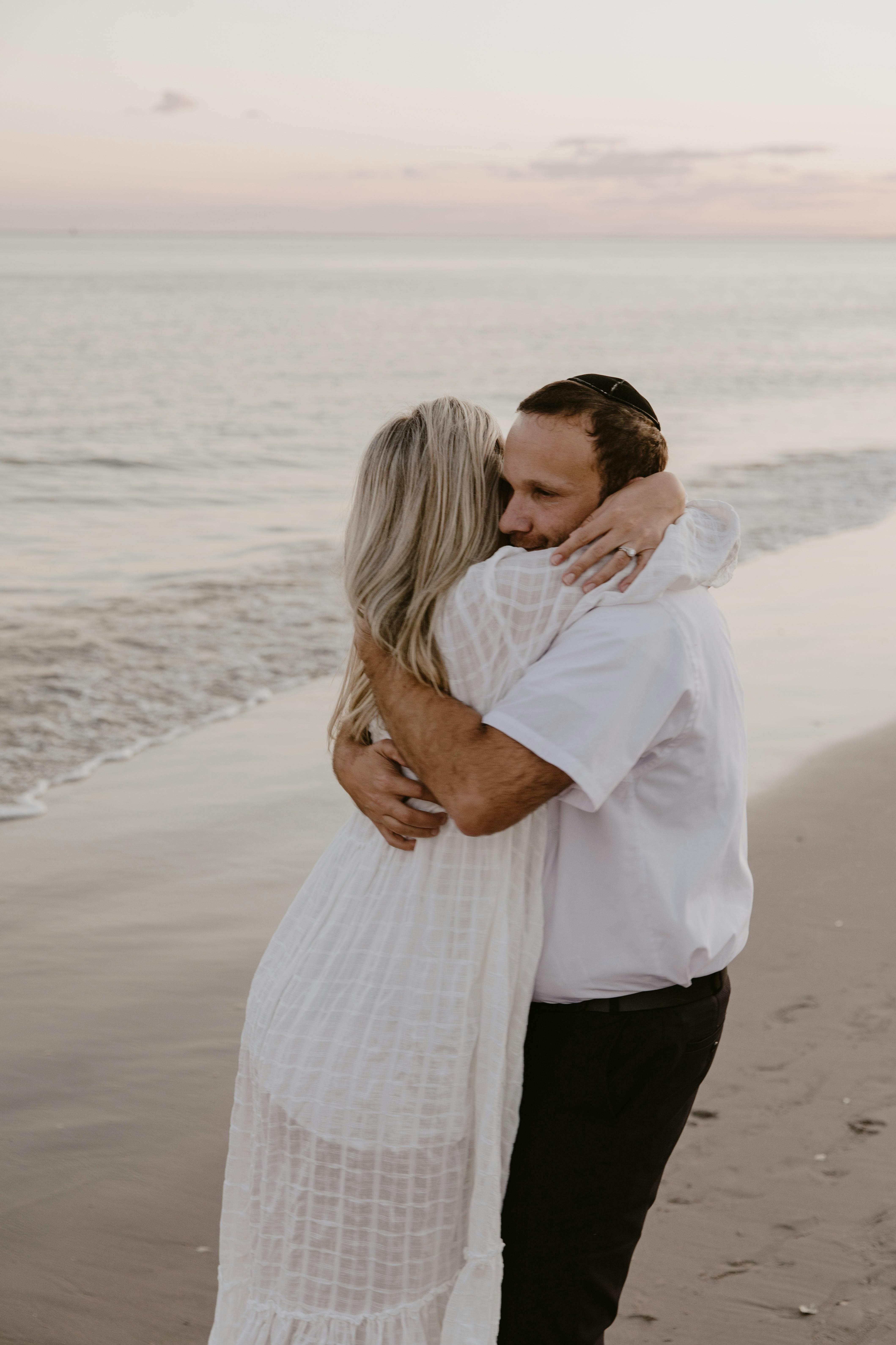 Man and Woman Walks Beside Green Sea · Free Stock Photo