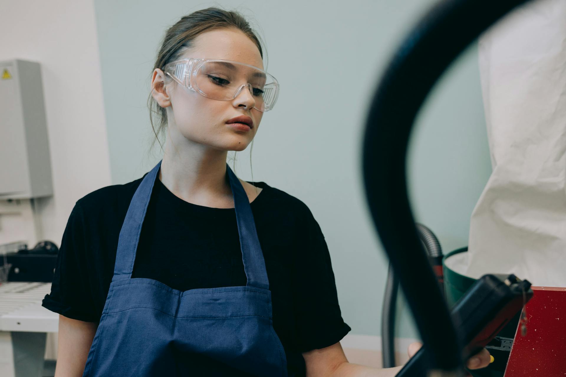 Woman in Blue Apron Wearing Protective Goggles