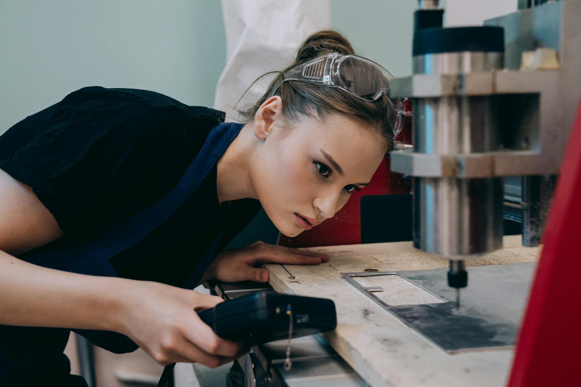 A Woman Watching a Cutter Machine