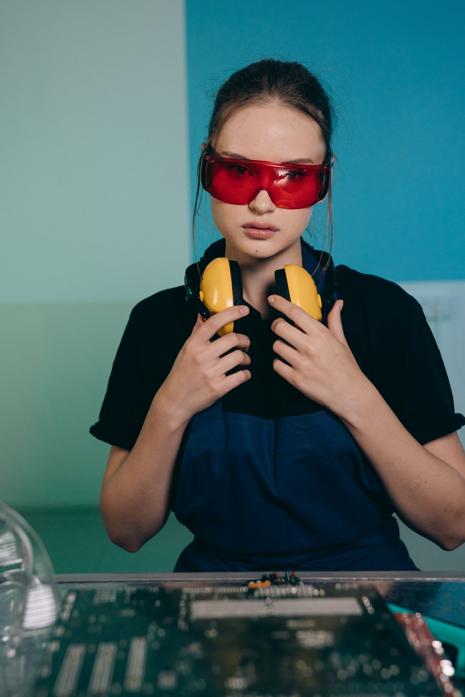 Workshop technician wearing safety glasses and hearing protection while working with precision tools