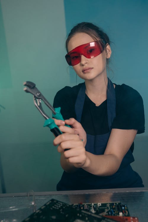 Beautiful Woman in Red Glasses Holding a Tool