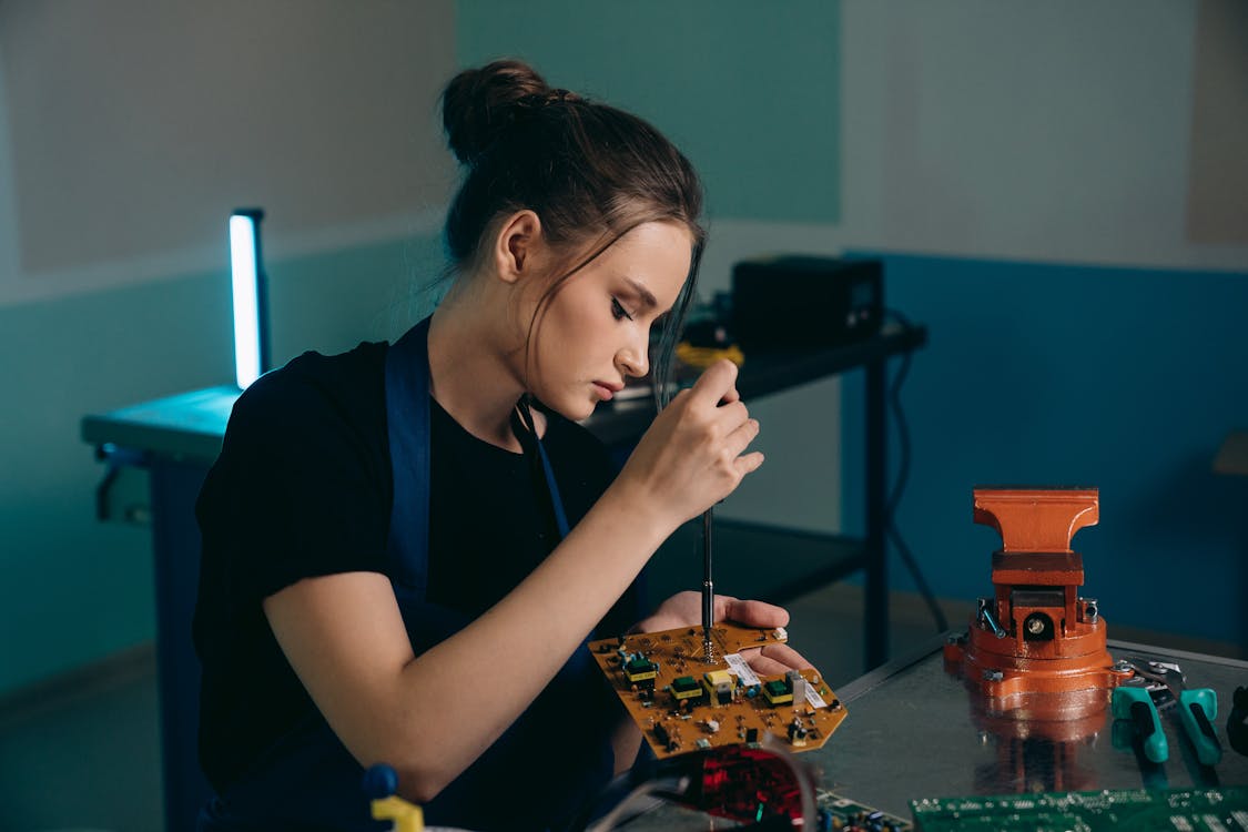 Woman Sitting and Working on Computer Hardware · Free Stock Photo