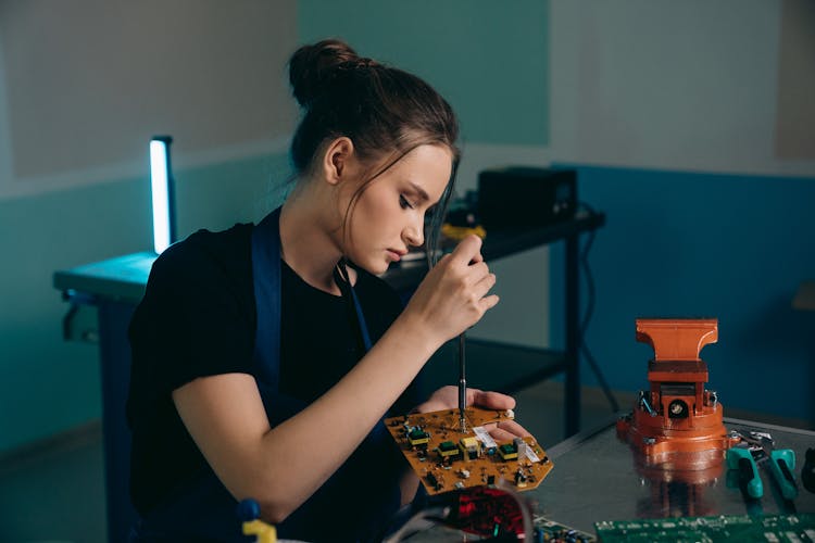 Woman Sitting And Working On Computer Hardware