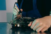 Person in Blue Long Sleeve Shirt Using Black Laptop Computer