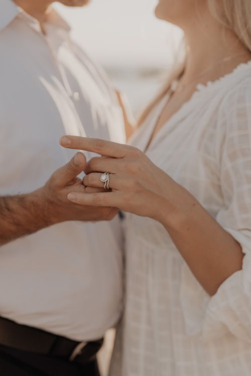 Free Close-up of couple gently holding hands, highlighting engagement ring in an intimate setting. Stock Photo