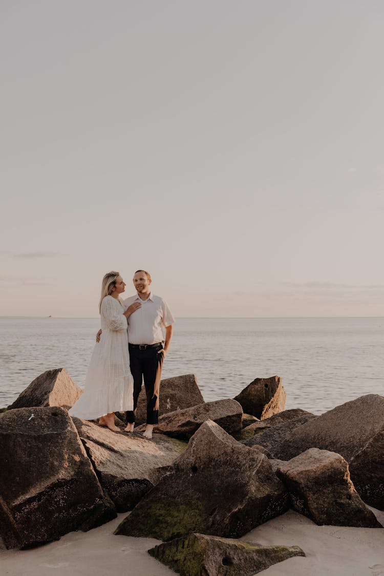 Couple Standing On Rock At The Beach