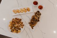 A selection of pastries elegantly arranged on a marble surface with two cups of tea.