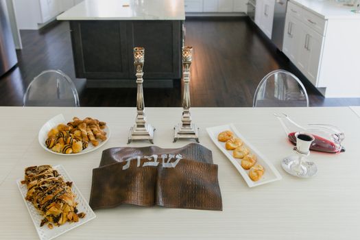 Elegant Shabbat table set with pastries and Kiddush wine, perfect for a festive Jewish gathering.