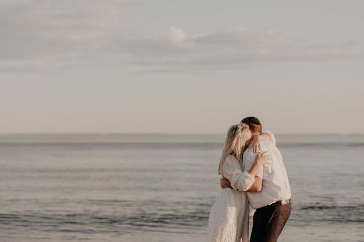 A Couple Embracing On A Beach