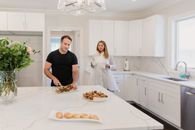 A couple enjoying pastries in a elegant kitchen setting.