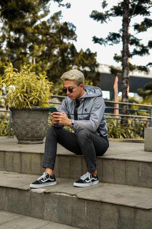 Man in Gray Jacket Sitting on Step