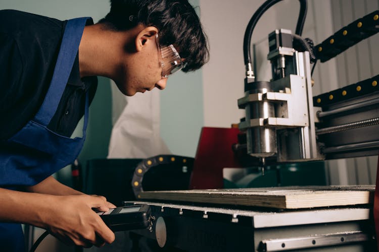 Man In Goggles By Industrial Machine