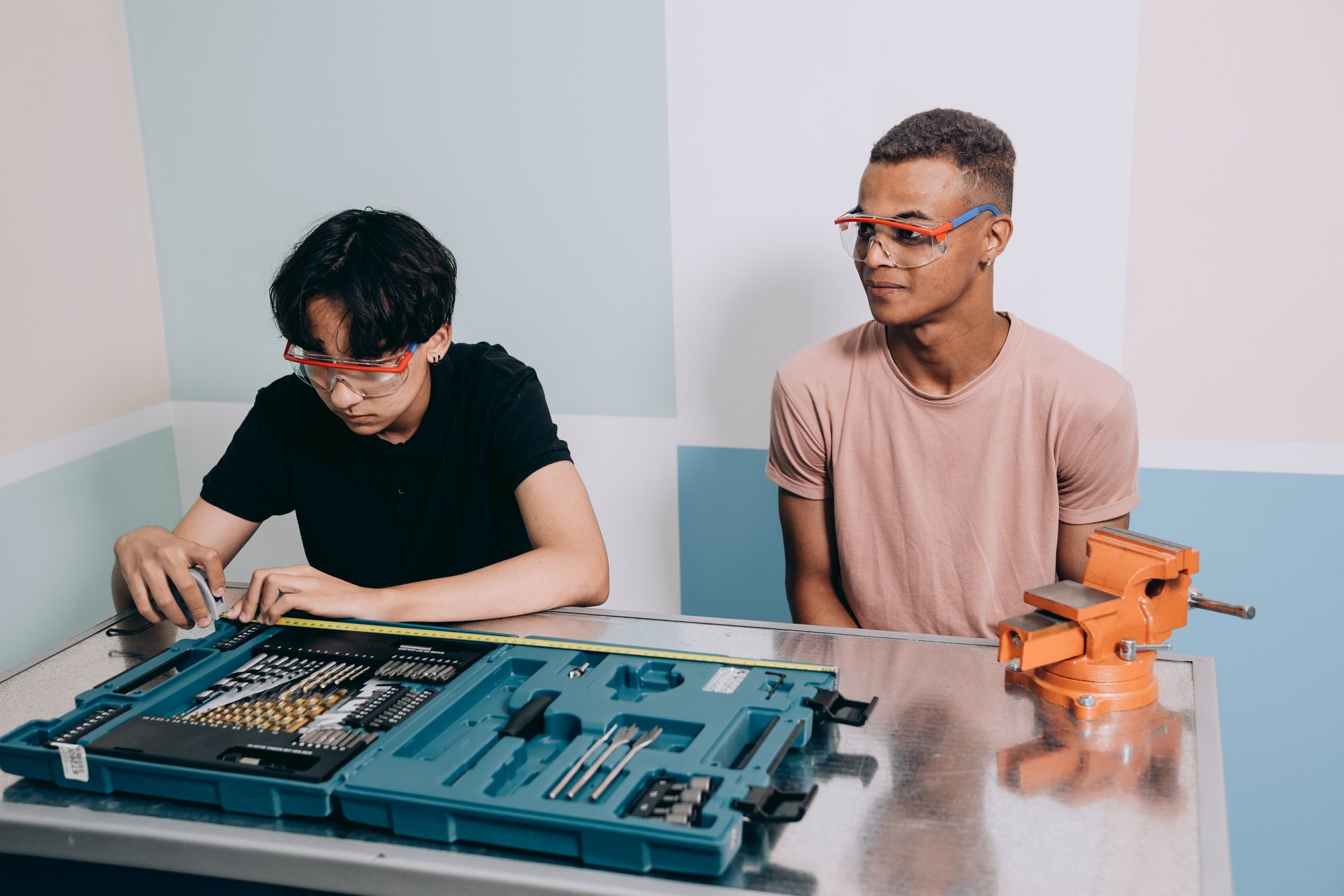 Two young men wearing safety glasses at work
