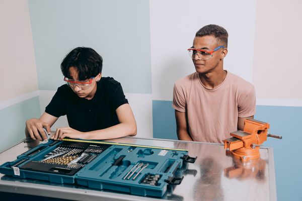 Two young men wearing safety glasses at work