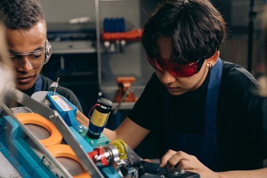 Two young engineers carrying out precision work in a technical workshop
