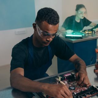 Karim Belhadj Portrait d'un technicien travaillant sur une carte électronique à l'établi
