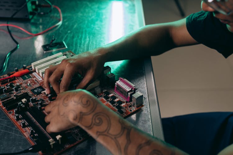 A Man Assembling A Computer Part