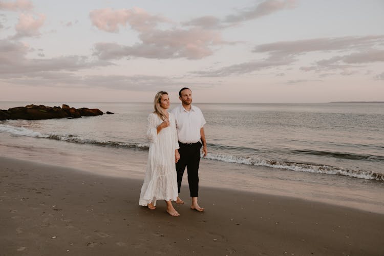 A Couple Walking On A Beach