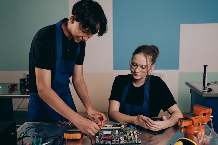 Man And Woman Testing A Motherboard