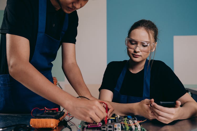 Man And Woman Testing A Motherboard Together