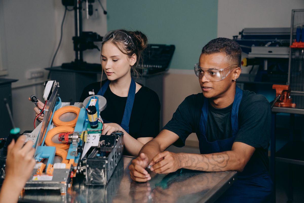 Deux apprentis en atelier avec leur formateur