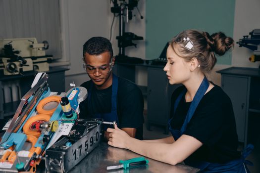 Young engineers assembling a robot in a technical workshop