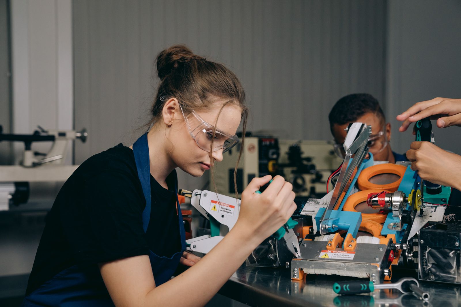 A Shrikewing technician fitting a rotor spar at the assembly bench — photo by Mikhail Nilov on Pexels